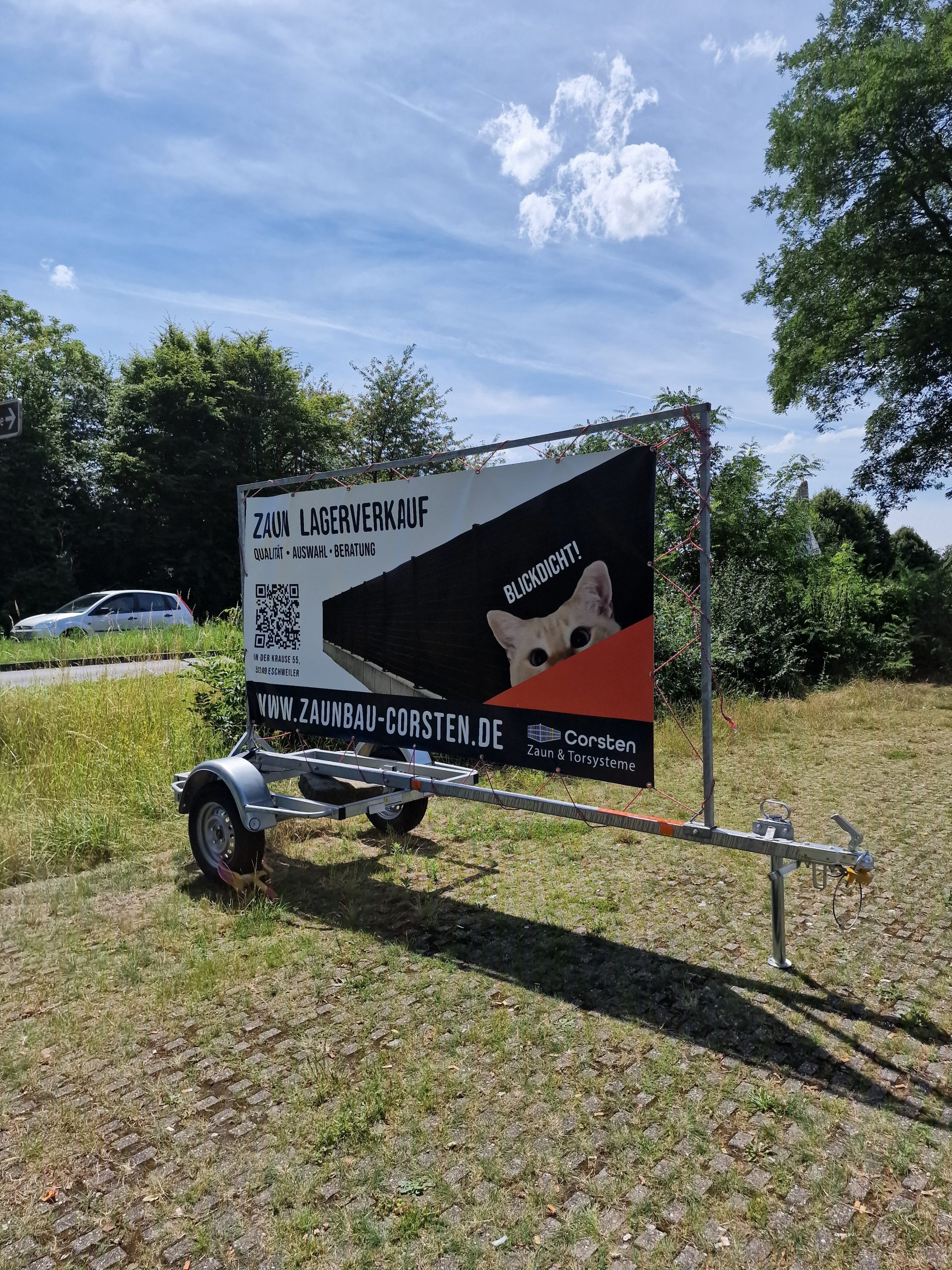 Mobiler Werbeanhänger mit großflächigem Banner für einen Zaun-Lagerverkauf