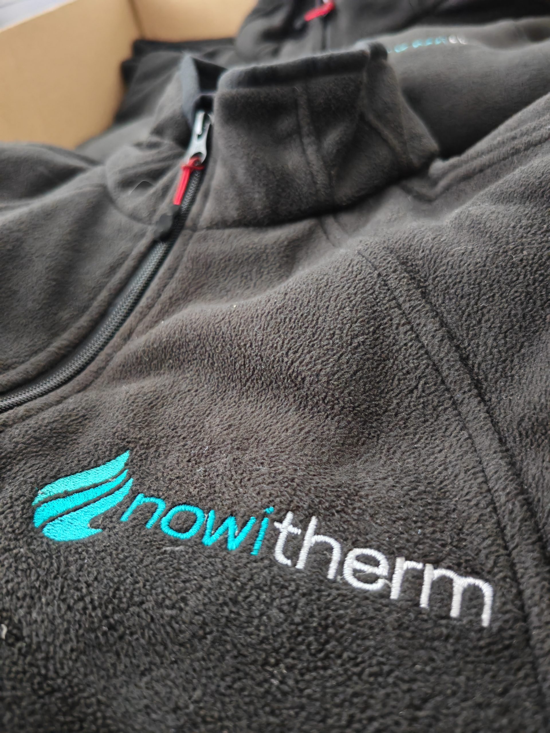 Detail einer bestickten schwarzen Fleecejacke