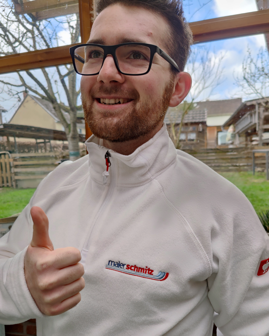Mitarbeiter von Maler Schmitz in bestickter weißer Fleecejacke